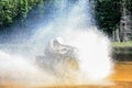 Man driving motocross ATV quad through splashing river lake water with high speed. Foy, Foyross Lake, Sudbury, Canada. Royalty Free Stock Photo