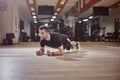 One young man, looking away, plank exercise, gym floor,