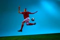 One young man, professional soccer football player training over soccer field background in neon light. Copy space for Royalty Free Stock Photo