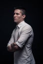 One young man, side view, looking tense, black background