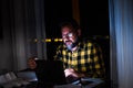 One young man using laptop and working on a computer at night at home. Businessman at job in his office Royalty Free Stock Photo