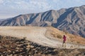 One young man walks alone in the desert through a pathway