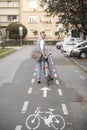 One young man, 20-29 years old, wearing hipster suit, smart casual, looking back to camera, rear view. in city on bike track Royalty Free Stock Photo