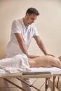 One young man physiotherapist massage woman back, laying on bed