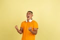 One young smiling handsome asian man in bright summer clothes with headphones isolated over yellow studio background. Royalty Free Stock Photo