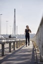 One young smiling woman, 20-29 years old, running on bridge Royalty Free Stock Photo