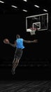 One young sportsman basketball player training in gym, idoors isolated on dark background. Concept of sport, game Royalty Free Stock Photo