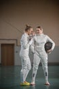 One young woman fencer laughing and another woman fencer looking at her