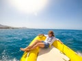 One young woman lying on a boat traveling and discovering the sea enjoying and relaxing with a sunny day - looking at the coast