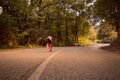 One young woman, outdoors jogging running, forest woods, road as Royalty Free Stock Photo