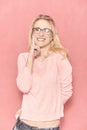 One young woman posing, looking to a camera, wearing eyeglasses, holding her finger on cheek Royalty Free Stock Photo