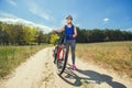 One young woman rides on a mountain bike outside of town on the road in the forest Royalty Free Stock Photo