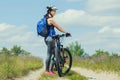 One young woman rides on a mountain bike outside of town on the road in the forest Royalty Free Stock Photo