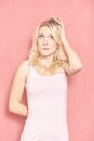 One young woman, 20-29 years old, scratching her long blond hair, thinking Royalty Free Stock Photo