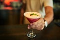 This ones on the house. Closeup of an unrecognizable barmen putting down a cocktail on the counter he just made inside