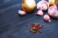 Onion, garlic, colored pepper peas on black wooden background Royalty Free Stock Photo