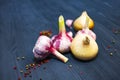 Onion, garlic, colored pepper peas on black wooden background Royalty Free Stock Photo