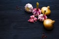 Onion, garlic, colored pepper peas on black wooden background Royalty Free Stock Photo