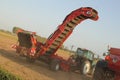 An onion harvester behind a tractor in dusty fields in holland in summer