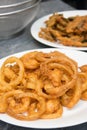 Onion ring in white dish with fried various vegetables on table. Royalty Free Stock Photo