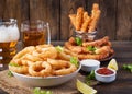 Onion rings in batter with sauce and cheese sticks. Beer snacks. Royalty Free Stock Photo