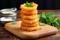 onion rings stacked like a pyramid on a chopping board