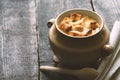 Onion soup in the ceramic pot on the old wooden table Royalty Free Stock Photo