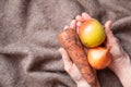 Onions, carrots and apple dirty in the hands of grandmother on the table, harvest, vegetables Royalty Free Stock Photo