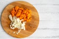 Onions and carrots chopped on a cutting board on a wooden table Royalty Free Stock Photo