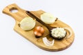 Onions cut in half and chopped on old wooden board on isolated white background Royalty Free Stock Photo