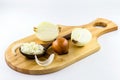 Onions cut in half and chopped on old wooden board on isolated white background Royalty Free Stock Photo