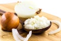 Onions cut in half and chopped on old wooden board on isolated white background Royalty Free Stock Photo