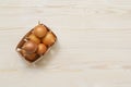 Onions in a wooden box on white wooden table. Top view. Royalty Free Stock Photo