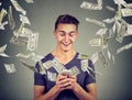 Online banking money transfer, e-commerce concept. Man using smartphone with dollar bills flying away from screen Royalty Free Stock Photo