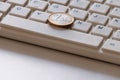 Online business. The concept of on-line sales. Coin in one Euro on the computer keyboard close-up. Spacebar and latin letters.