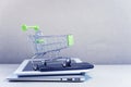 Online business and e-commerce or shopping online concept. Shopping basket on top of stack of laptop, tablet and mobile phone. Wi Royalty Free Stock Photo