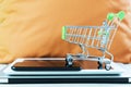 Online business and e-commerce or shopping online concept. Shopping basket on top of stack of laptop, tablet and mobile phone. Royalty Free Stock Photo