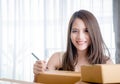 Online business owner is writing address on boxes to send to customer home Royalty Free Stock Photo