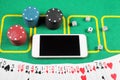 Online casino concept, chips, cards and dice lie next to a smartphone Royalty Free Stock Photo