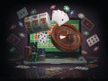 Online casino concept. Laptop with roulette, slot machine, casino chips and playing cards isolated on black background. Royalty Free Stock Photo