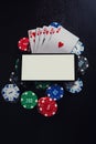 Online casino gambling concept. Smartphone blank screen on chips stack and royal flush playing cards poker combination over black Royalty Free Stock Photo