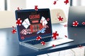 Online casino and gaming, gambling on device concept. Close up of laptop computer at desk with creative slot machine and other Royalty Free Stock Photo