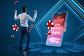 Online casino and gaming, gambling on device concept. Happy european businessman and smartphone with creative slot machine and Royalty Free Stock Photo
