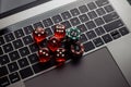 Online casino theme. Gambling chips and five red dices on laptop keyboard. Top view Royalty Free Stock Photo