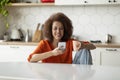 Online Communication. Beautiful Black Woman Using Smartphone And Drinking Coffee In Kitchen Royalty Free Stock Photo