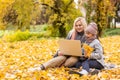 Online communication. Family using laptop and video calling , sitting on picnic blanket in garden.