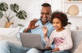 Online communication during lockdown. Mature African American man with granddaughter chatting via laptop at home Royalty Free Stock Photo