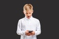 Online communication surprised boy reading phone Royalty Free Stock Photo