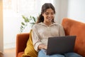 Online Communication. Young Female Using Laptop While Sitting On Couch At Home Royalty Free Stock Photo