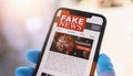 Online Corona Fake news on a mobile phone. Close up, man reading Fake news or articles about covid-19 in a smartphone screen appli Royalty Free Stock Photo